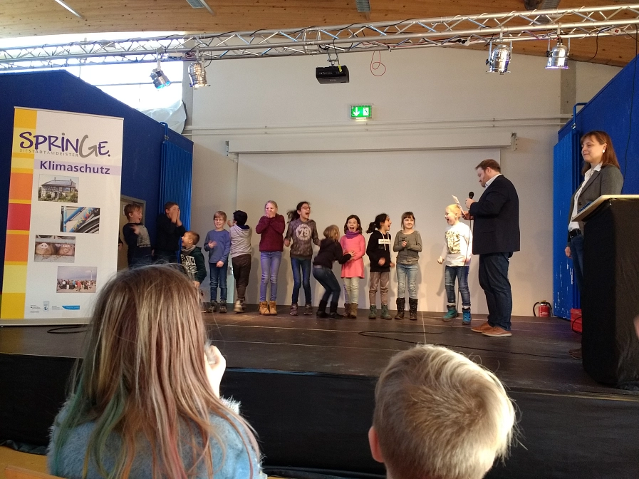 Bürgermeister Christian Springfeld übergibt die Prämie an die Grundschule am Ebersberg